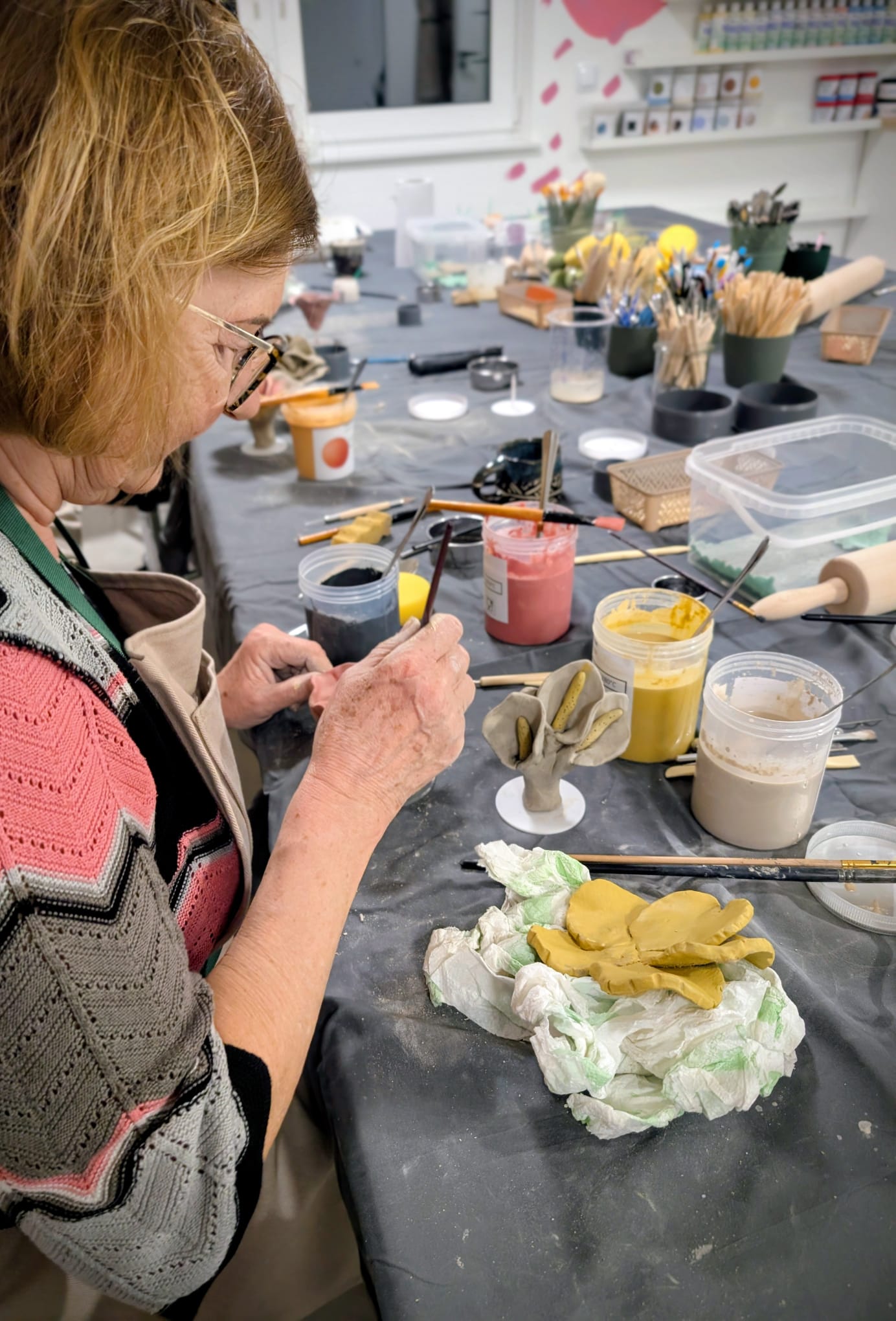 Uczestniczka lepiąca ceramiczne kwiaty z gliny